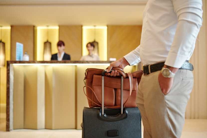 cropped-image-hotel-guest-standing-lobby-with-luggage-after-checking-1.jpg