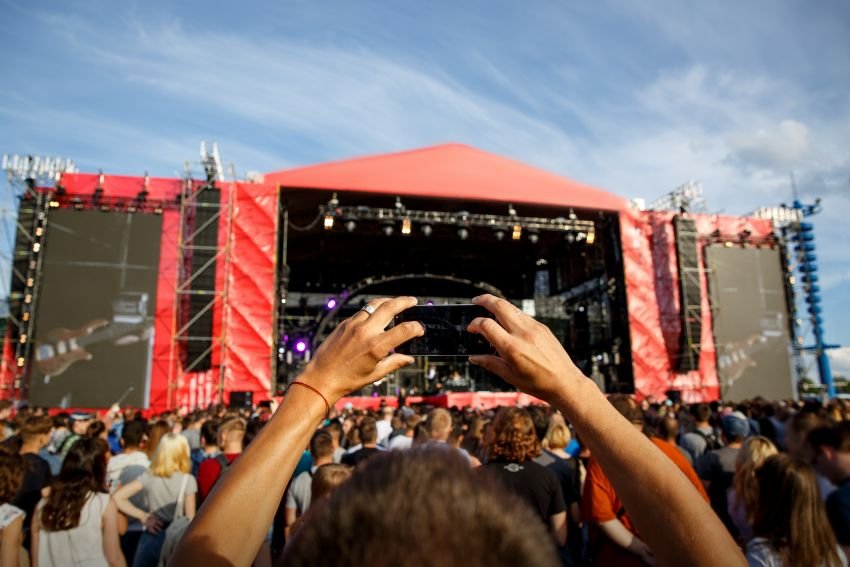 man-holding-smartphones-hands-photographing-summer-outdoor-music-concert-festival-1.jpg